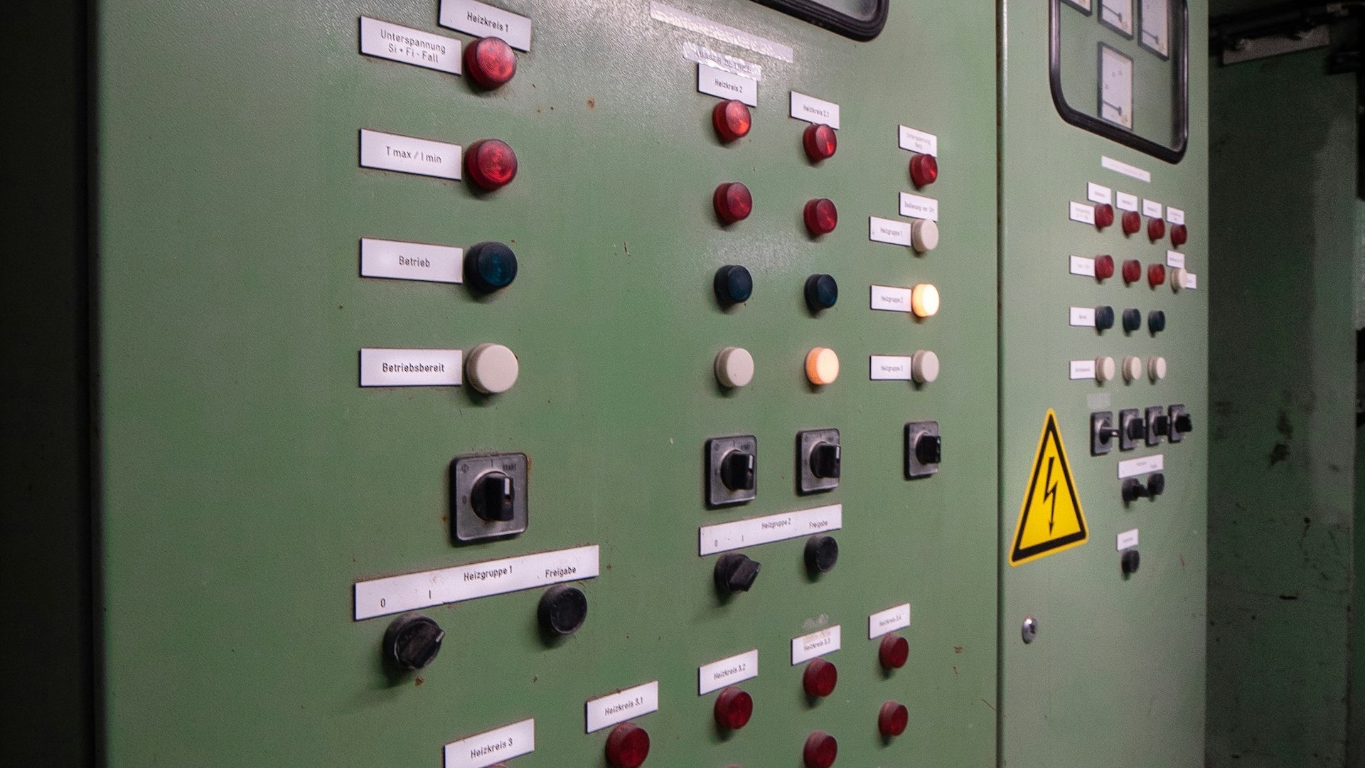 Cuadro de control industrial antiguo con pilotos, conmutadores y señal de alta tensión