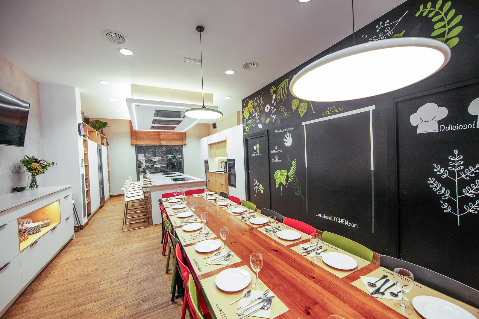 Comedor de bcnKITCHEN El Born, con la mesa larga y la pizarra